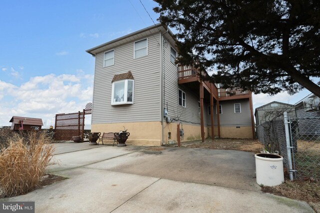 exterior space with driveway, fence, and a patio area