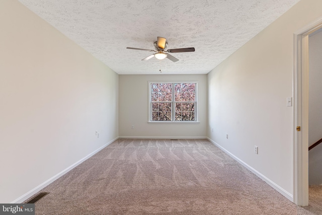 empty room with ceiling fan, carpet floors, a textured ceiling, and visible vents