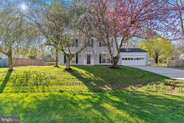 view of front of house featuring a front lawn, driveway, fence, and a garage