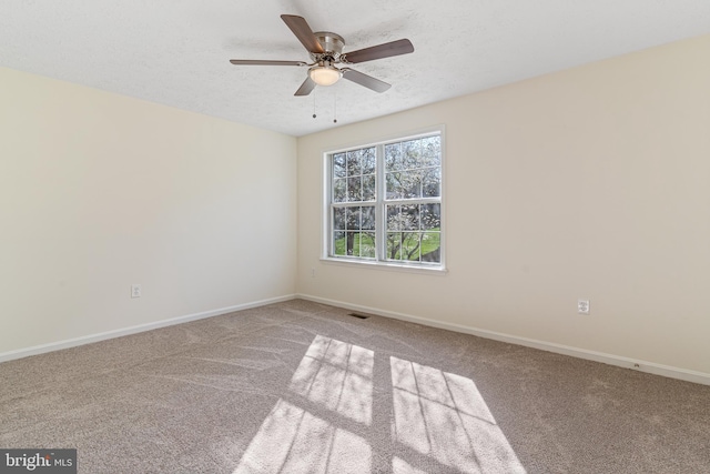 unfurnished room featuring a ceiling fan, a textured ceiling, carpet floors, baseboards, and visible vents