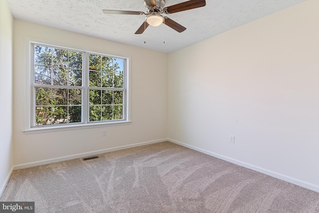 empty room featuring baseboards, visible vents, carpet flooring, and ceiling fan