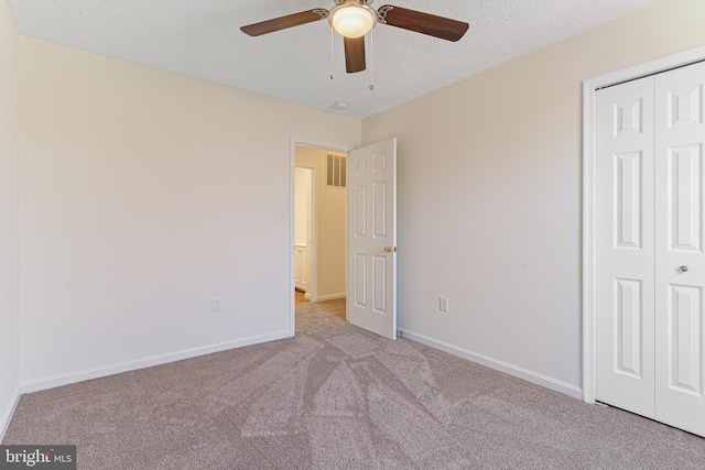 unfurnished bedroom featuring baseboards, carpet flooring, visible vents, and a closet