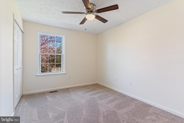 unfurnished bedroom with a textured ceiling, a closet, baseboards, carpet flooring, and visible vents