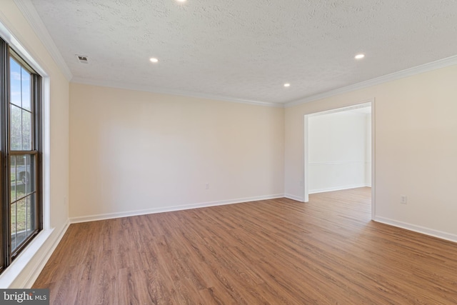 empty room featuring baseboards, wood finished floors, a textured ceiling, and recessed lighting