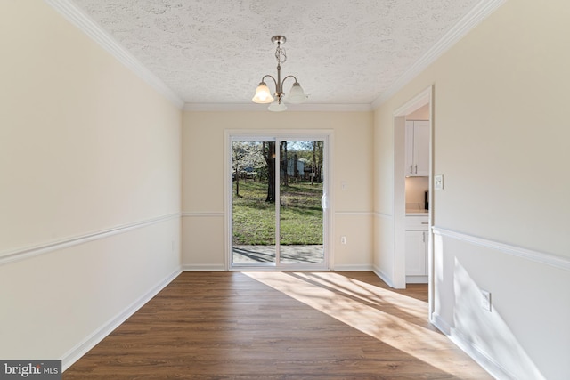 unfurnished dining area featuring baseboards, wood finished floors, a chandelier, and ornamental molding