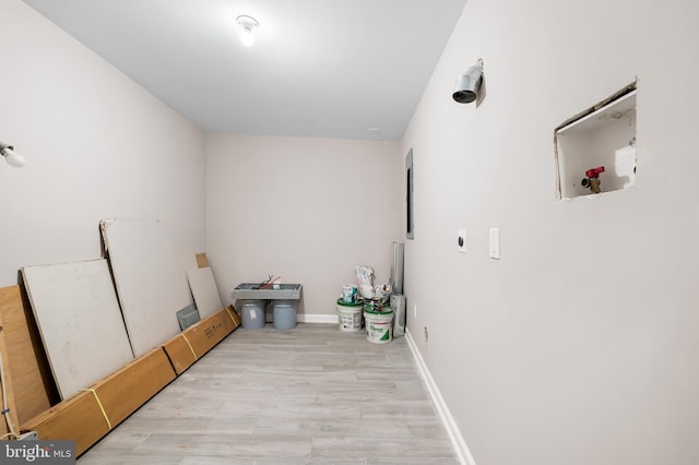 738 N Patterson Park Ave, Baltimore, MD 21205 - clothes washing area featuring baseboards and wood finished floors