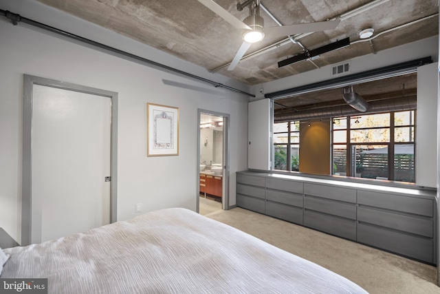 bedroom with ensuite bathroom, visible vents, and carpet floors