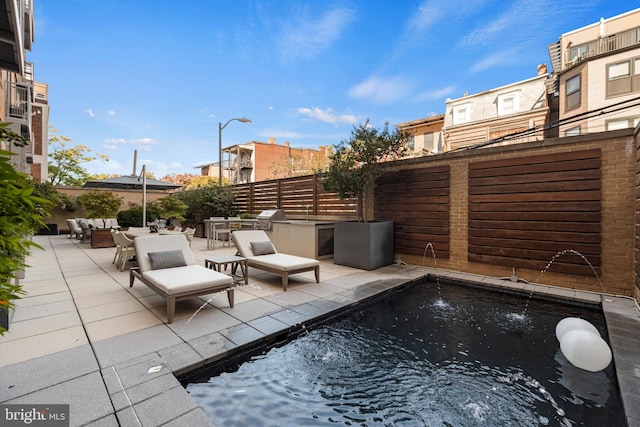 view of patio / terrace with area for grilling, a grill, fence, and an outdoor living space