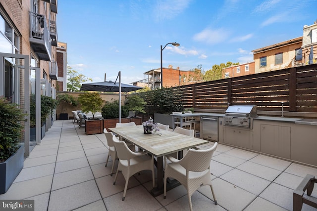 view of patio / terrace with a grill, outdoor dining space, area for grilling, and fence