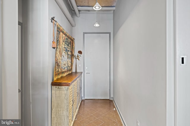 hallway with tile patterned flooring and baseboards