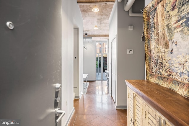 corridor featuring baseboards and tile patterned floors