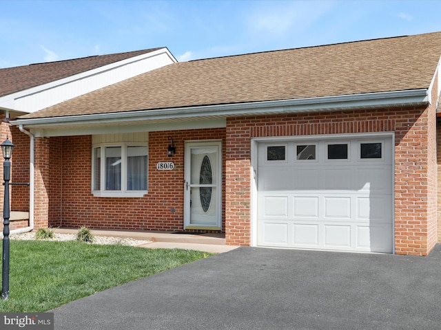 single story home with roof with shingles, brick siding, driveway, and an attached garage