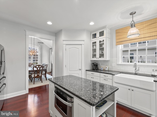 kitchen featuring backsplash, open shelves, oven, and a sink
