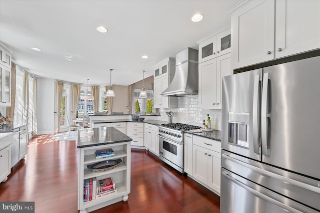 kitchen with open shelves, stainless steel appliances, a peninsula, wall chimney range hood, and decorative backsplash