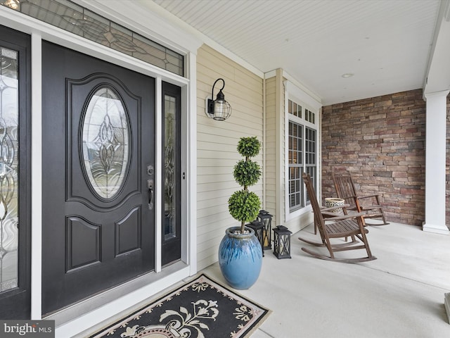 entrance to property with stone siding and a porch