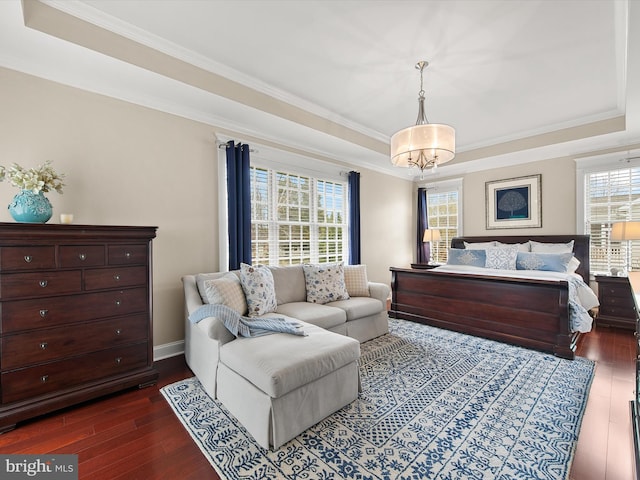 bedroom featuring a tray ceiling, crown molding, and dark wood-style flooring