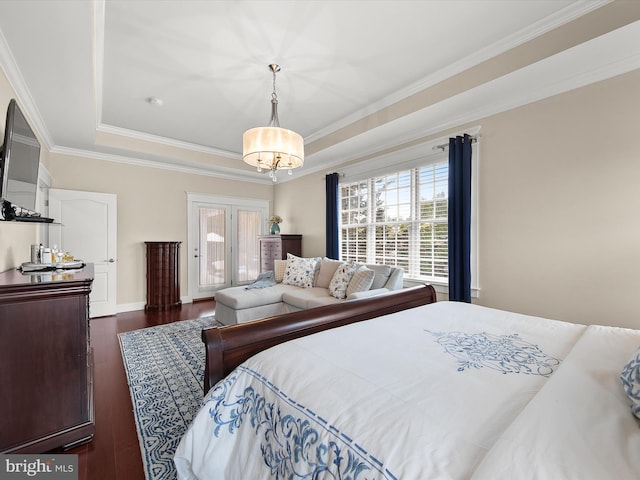 bedroom with baseboards, dark wood-type flooring, crown molding, a raised ceiling, and a chandelier