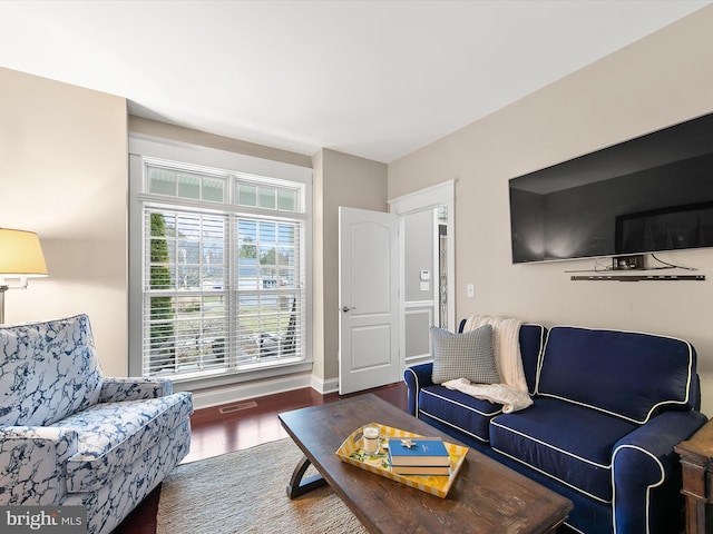 living room featuring wood finished floors, visible vents, and baseboards
