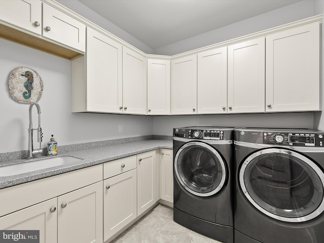 laundry room featuring washer and clothes dryer, cabinet space, and a sink