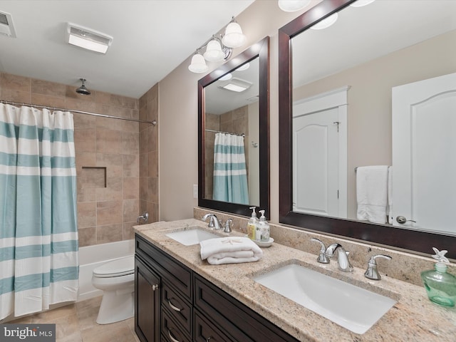 bathroom featuring a sink, shower / bath combo with shower curtain, toilet, and double vanity