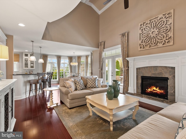 living room featuring a fireplace, recessed lighting, dark wood-style flooring, ceiling fan, and french doors