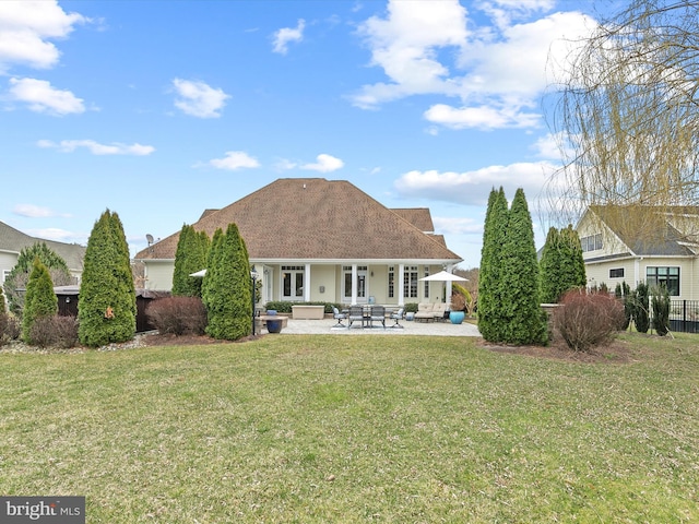 rear view of house featuring a patio area and a yard