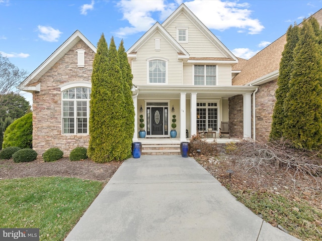 traditional-style home featuring a porch and stone siding