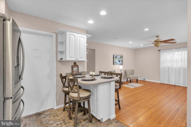 119 Rieck Ave, Millville, NJ 08332 - kitchen featuring stainless steel refrigerator with ice dispenser, a kitchen breakfast bar, white cabinetry, a peninsula, and recessed lighting