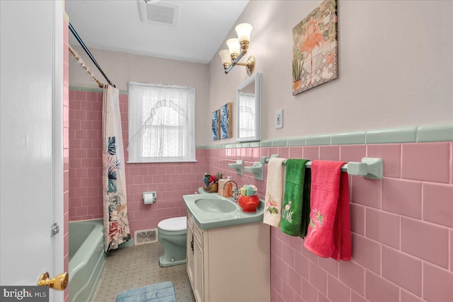 119 Rieck Ave, Millville, NJ 08332 - bathroom featuring tile walls, vanity, toilet, a wainscoted wall, and shower / bathtub combination with curtain