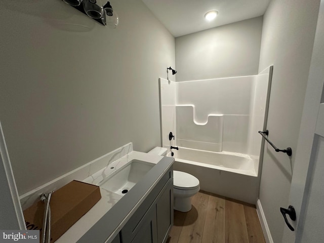 full bath with toilet, vanity,  shower combination, and wood finished floors