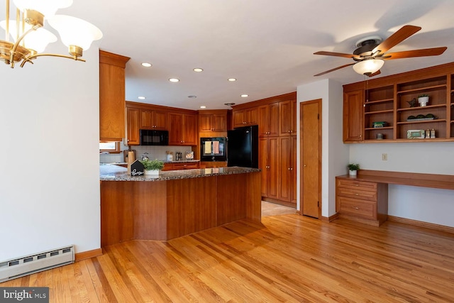 kitchen featuring a baseboard radiator, light wood-style floors, a peninsula, brown cabinetry, and black appliances