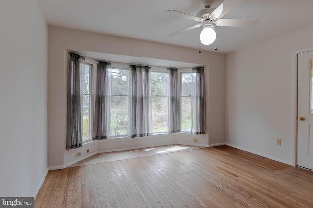 unfurnished room featuring baseboards, a ceiling fan, and hardwood / wood-style floors