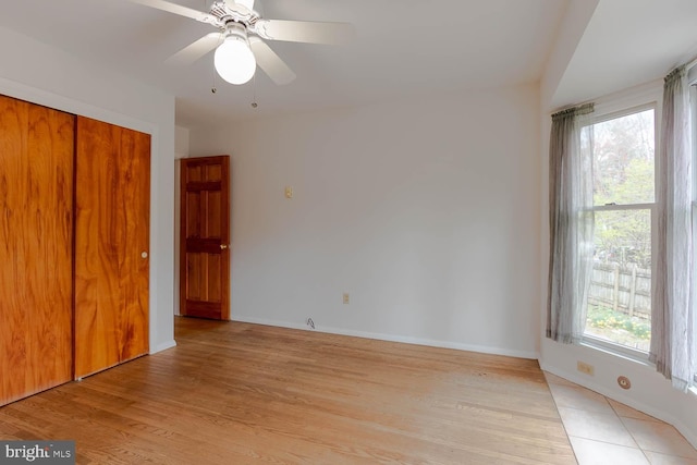unfurnished bedroom featuring light wood-style flooring, a closet, and baseboards
