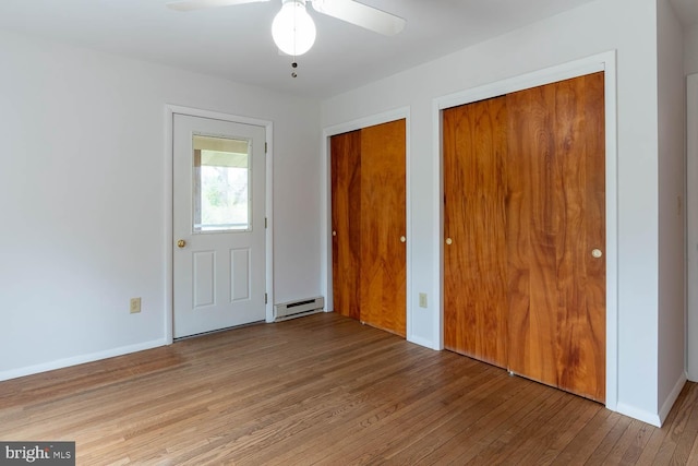 entryway featuring a baseboard radiator, wood finished floors, ceiling fan, and baseboards