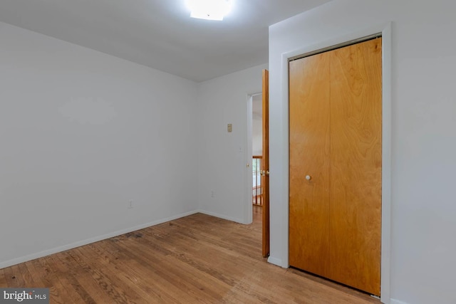 empty room with baseboards and wood finished floors