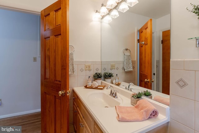 bathroom featuring tile walls, wainscoting, vanity, and wood finished floors