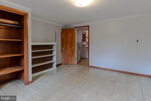 unfurnished bedroom with ornamental molding, baseboards, and a walk in closet