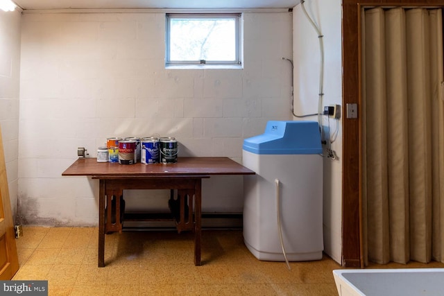 laundry area with laundry area, concrete block wall, and light floors