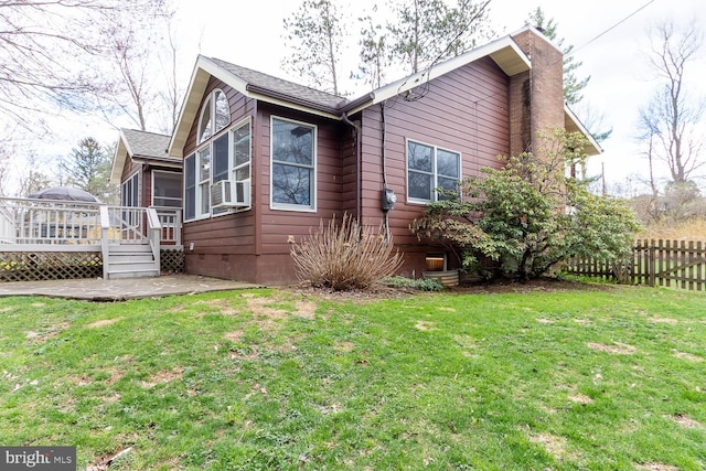 view of property exterior featuring a yard, crawl space, a chimney, fence, and a wooden deck