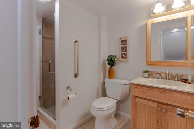 full bath with baseboards, toilet, vanity, tile patterned flooring, and a stall shower