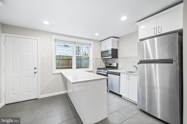 618 Mcclellan St, Philadelphia, PA 19148 - kitchen with appliances with stainless steel finishes, white cabinetry, backsplash, a sink, and recessed lighting