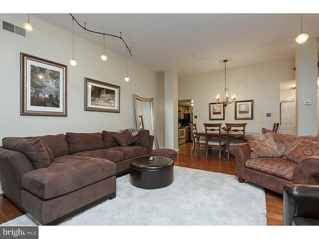1023 Clinton St Unit 204, Philadelphia, PA 19107 - living area featuring visible vents, wood finished floors, and an inviting chandelier
