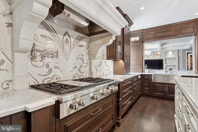 kitchen with decorative backsplash, dark wood-style flooring, a sink, stainless steel gas stovetop, and recessed lighting
