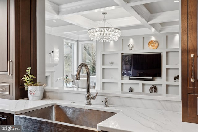 interior space with light stone countertops, a chandelier, a sink, and coffered ceiling