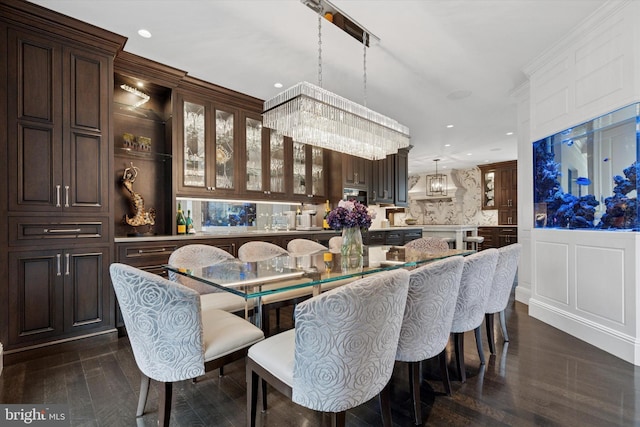dining space with recessed lighting, dark wood finished floors, and a decorative wall