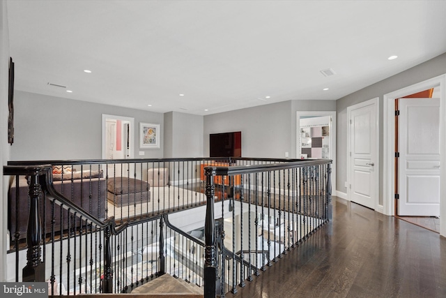 hallway with recessed lighting, baseboards, an upstairs landing, and wood finished floors