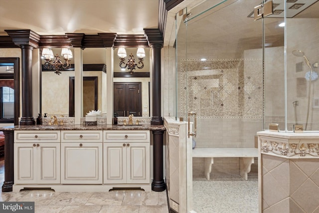 bathroom featuring double vanity, a sink, decorative columns, and a tile shower