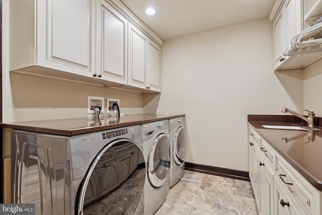 laundry room with washing machine and clothes dryer, baseboards, a sink, and cabinet space