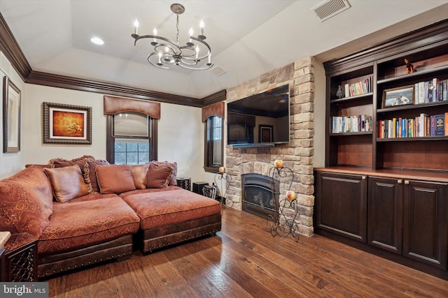 living area featuring visible vents, ornamental molding, a fireplace, a chandelier, and dark wood finished floors