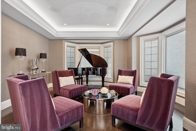 living area featuring a tray ceiling, a healthy amount of sunlight, and wood finished floors